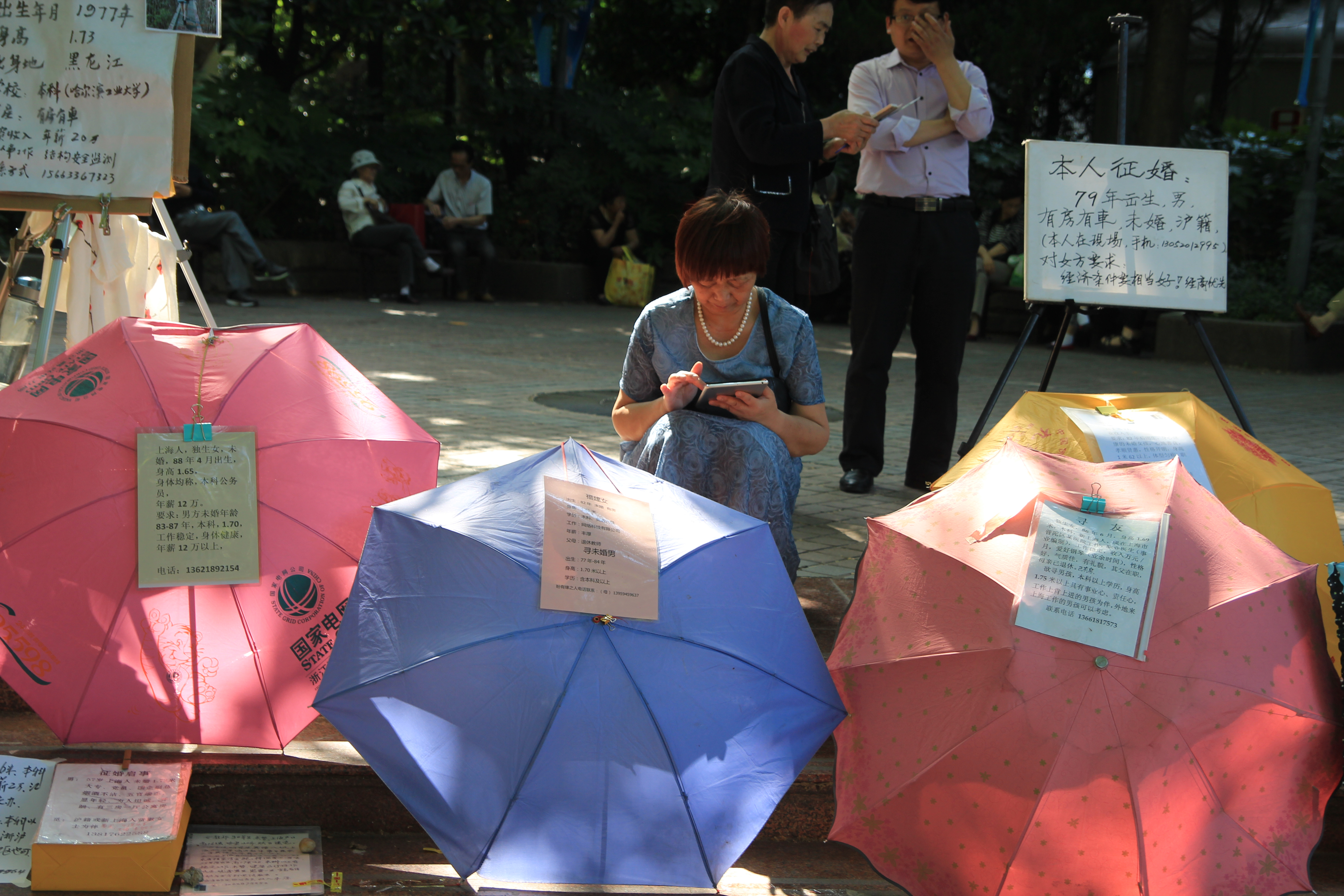 A woman sits behind umbrellas at the Shanghai marriage market