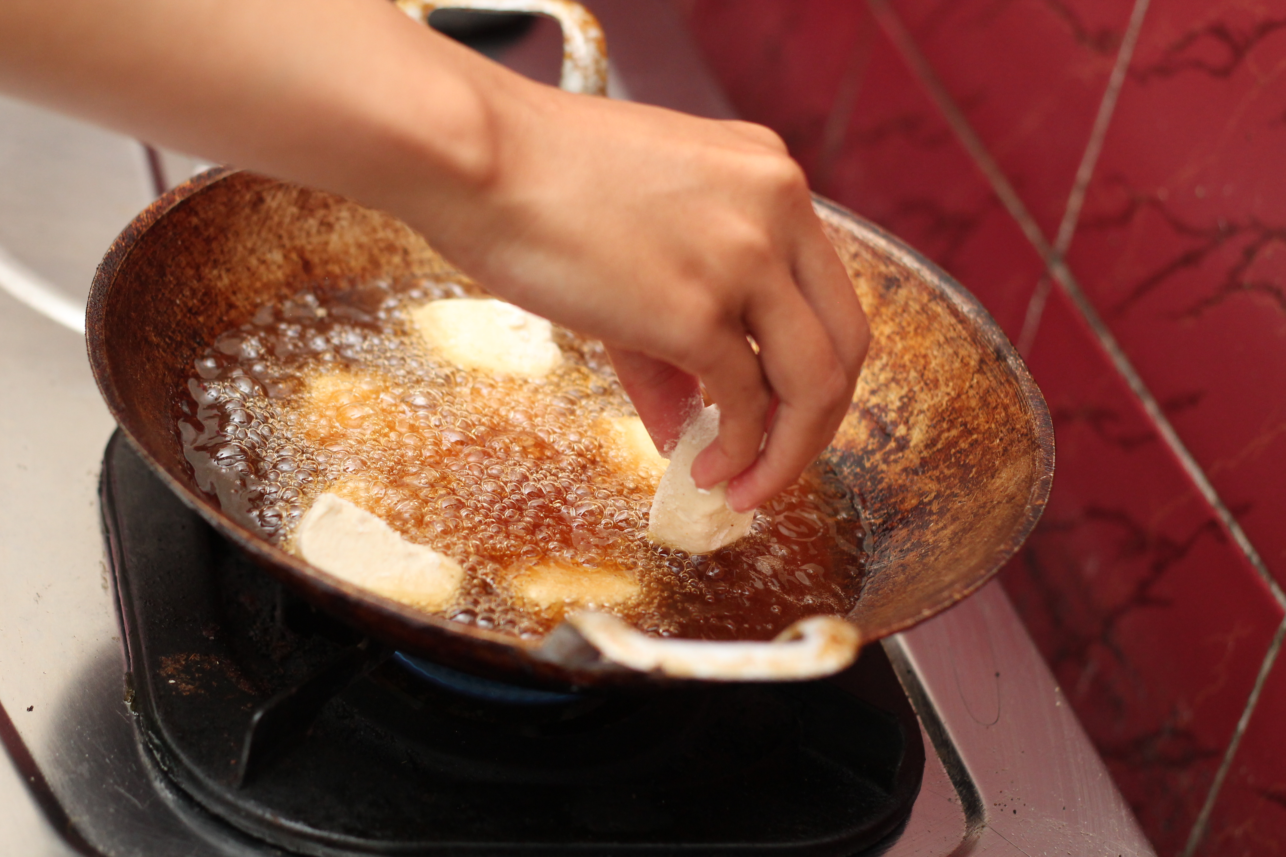 Frying tofu in a wok on a gas stove